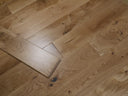 Lacquered solid wood flooring boards with visible knots, light oak grain texture