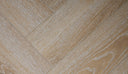 Honey oak herringbone vinyl flooring showing plank grain and seam lines